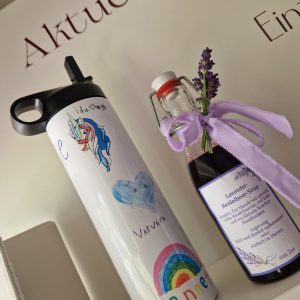 Eine weiße Thermoflasche mit bunten Kinderzeichnungen, als Abschiedgeschenk für Lehrer/Lehrerin Erzieherin